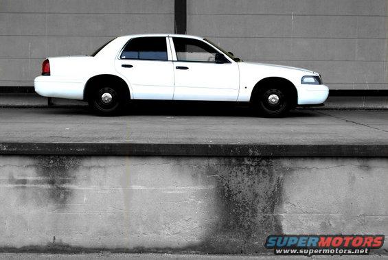 1998 Ford Crown Victoria sedan, side view, parked against a concrete wall
