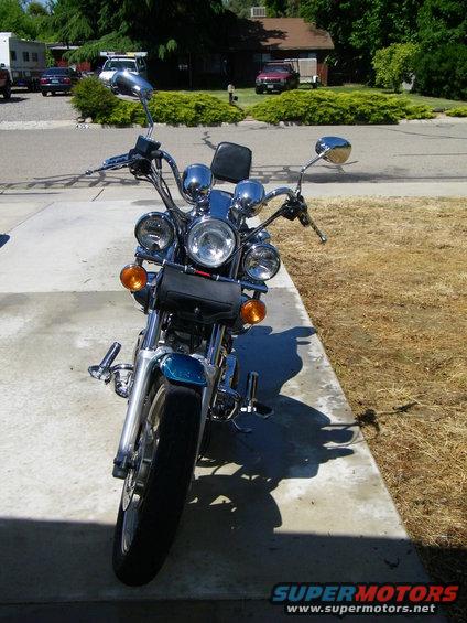 Front view of a cruiser motorcycle parked on a concrete driveway