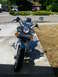 1992 Yamaha Virago - A motorcycle is parked on a concrete surface in front of a residential house on a sunny day.