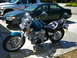 1992 Yamaha Virago - A teal motorcycle is parked on a concrete driveway next to a dark green sedan and a silver truck.