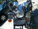 1992 Yamaha Virago - A motorcycle's front view, multiple chrome headlights and a black pouch, is parked beside a car.