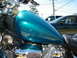 1992 Yamaha Virago - A teal motorcycle's fuel tank is shown, with a dark sedan visible in the background.