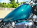 1992 Yamaha Virago - Close-up of a teal motorcycle fuel tank and engine details under a sunny sky.