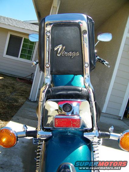Rear view of a teal motorcycle with a black seat and chrome accents. 'Virago' is visible on the backrest