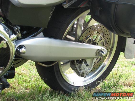 motorcycle rear wheel, brake disc, caliper, and swingarm detail