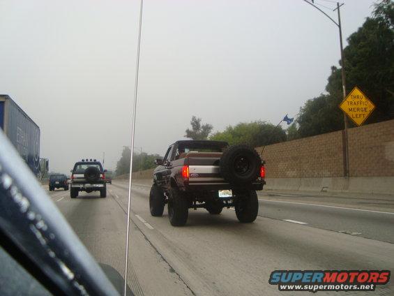 Rear view of a lifted 1986 Ford Bronco with a spare tire on the back