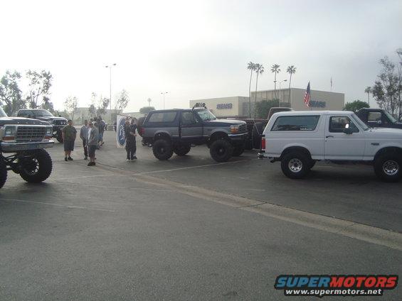 Lifted 1987-1991 Ford Bronco parked next to a white 1987-1991 Ford Bronco and a lifted older Ford truck