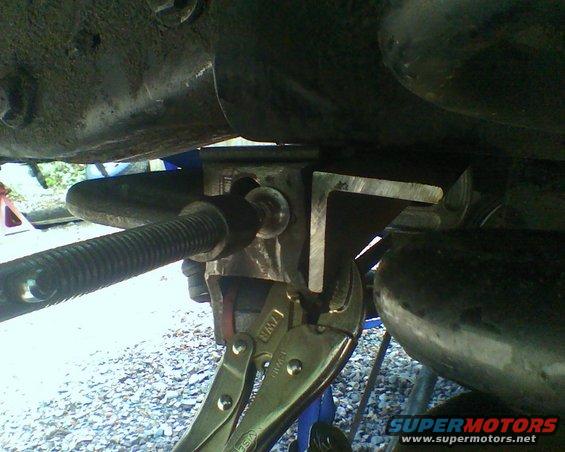 close-up of vehicle suspension component with vise grips attached