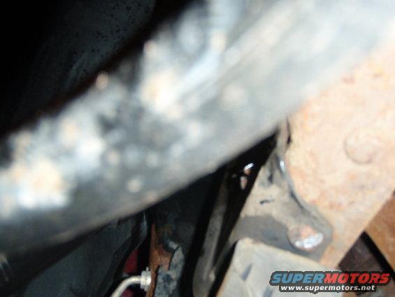 Close-up of rusty vehicle frame and suspension parts. Supermotors.net logo visible