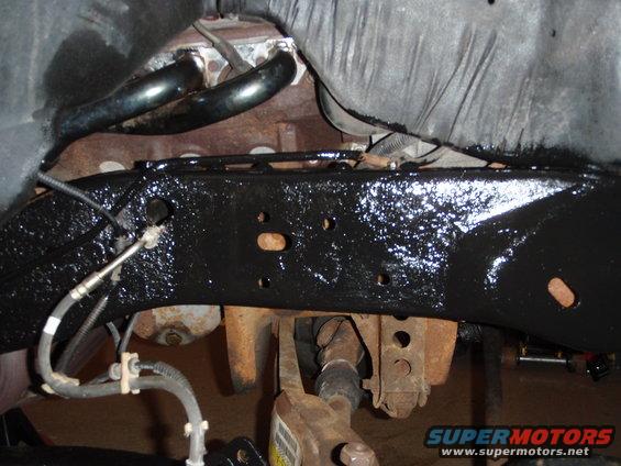 Black painted vehicle frame with exhaust manifold and drive shaft visible