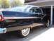1956 Ford Fairlane - A classic black 1956 Ford Fairlane coupe is parked in a driveway, its distinctive chrome accents and whitewall tires.