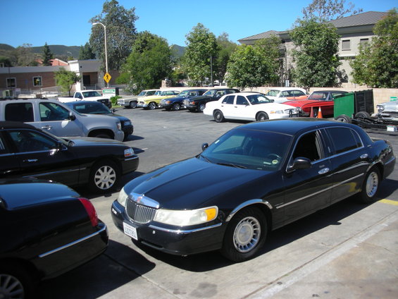 Black Lincoln Town Car with chrome trim, parked in a lot