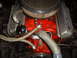 1956 Ford Fairlane - Detailed view of a V8 engine, red block, chrome valve covers, and braided fuel lines.
