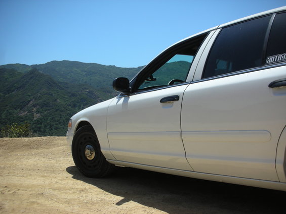 2004 Ford Crown Victoria side view, parked on dirt road with mountains