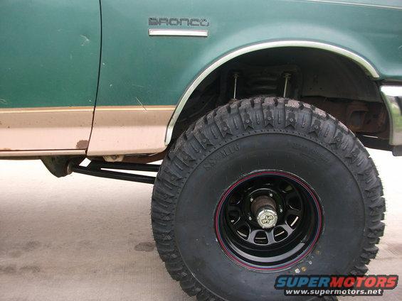 Green Ford Bronco side view with large off-road tire and tan trim