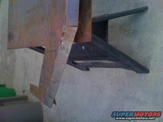 Rusted metal bracket with black frame underneath