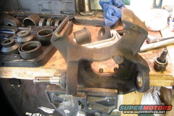 bronco-006.jpg New upper joint pressed in.  Look in far middle and you can see the press and cup I used to get it in.  Take the grease cap off the ball joint first so not to damage it.  Remember, this time around put the upper in first, then the lower.  I read a tip on some other web page with ball joint instructions to put the new ball joints in the freezer a while you're taking apart the front end.  They're frozen and shrink just a bit, making it easier getting them in.  I did it, and installing them wasn't bad at all...

Once the both ball joints are in, install the zerks for greasing and grease them up.  I didn't have a gun, so I got one locally for $20.  Remove the zerks and save for later use.  They need to come out due to clearance issues, especially for the upper ball joing.  Right under it is where the axle U joint is spinning.  
