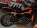 1979 Jeep CJ7 - A side view of a Harley-Davidson motorcycle with distinctive orange and black paintwork, parked indoors.