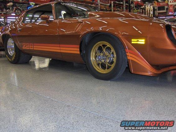 1979 Chevrolet Camaro drag car with orange and red stripes on the side and gold wheels