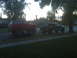 1987 Ford Bronco - Two lifted trucks, a red Bronco and a black F-Series, are parked side-by-side on a street.