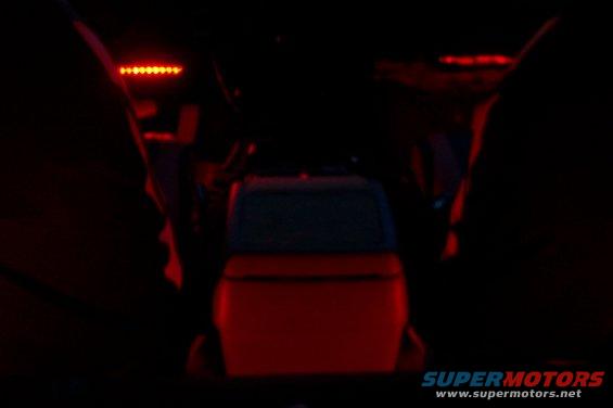 view from back seat looking forward, red lights on top, red interior