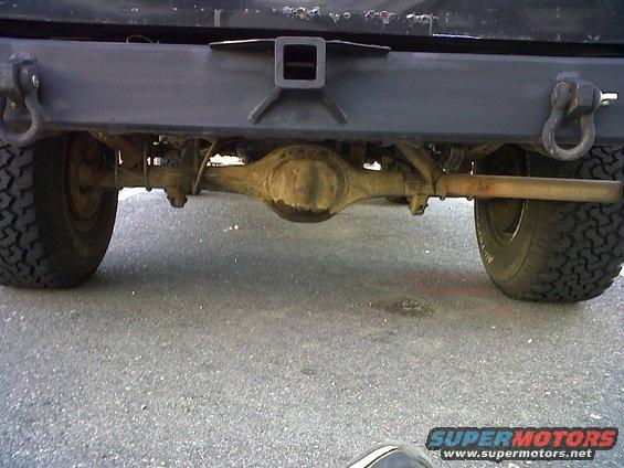 Rear view of a vehicle showing the differential, exhaust pipe, and tow hitch receiver