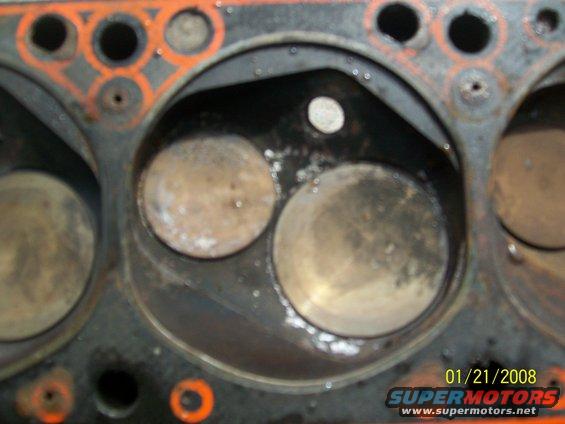 Engine cylinder head with two valves visible, showing signs of wear