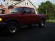 1997 Ford Ranger - A red Ford Ranger pickup truck is parked in front of a house on a cloudy day.