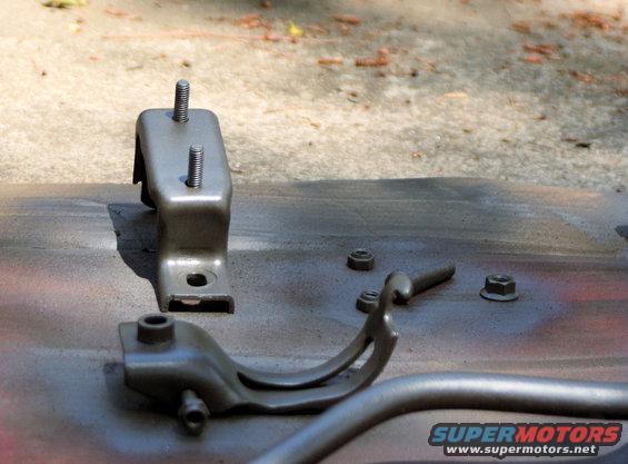 Engine mounts and nuts on a surface, possibly being painted