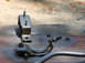 1976 Ford Ranchero - Several metal automotive parts, including engine mounts and fasteners, are laid out on a surface.