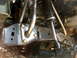 1996 Ford Bronco - Close-up view of aftermarket suspension modifications on a vehicle's frame.