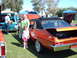 1992 Ford Bronco - A car show scene with people gathered around classic vehicles on a sunny day.
