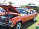 1992 Ford Bronco - This orange 1970 Chevrolet Nova is displayed with its hood open at an outdoor car show.
