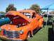 1992 Ford Bronco - Orange 1950 Chevrolet pickup truck on display at a car show, with hood open.