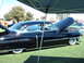 1992 Ford Bronco - A classic black Cadillac is displayed with its hood open at an outdoor event, with other vehicles in the background.