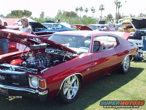 Red 1970 Chevrolet Chevelle SS coupe with hood open, chrome wheels, and custom interior