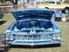 1992 Ford Bronco - Front view of a blue 1959 Chevrolet Impala at a car show, with a pickup truck in the background.