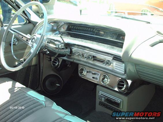 Car interior with light blue steering wheel, chrome dashboard, and aftermarket stereo system