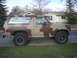 1985 Ford Bronco - This Ford Bronco has a distinctive camouflage paint scheme and is parked in front of a residential house.