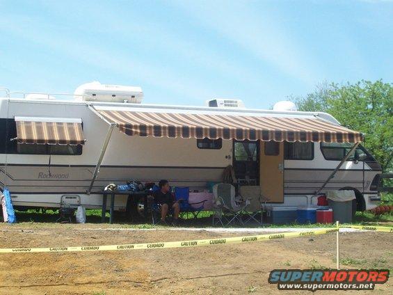 Motorhome with awning extended, people sitting outside