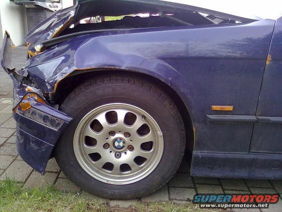 Damaged blue 1998 BMW 3 Series front quarter panel and wheel