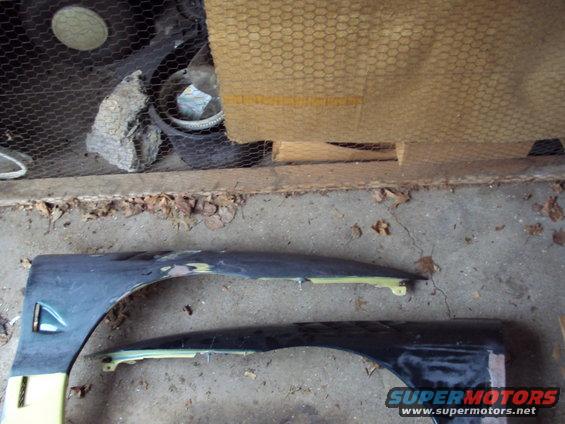 Two dark car fenders, one with yellow trim