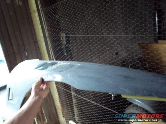 Gray car fender held by hand