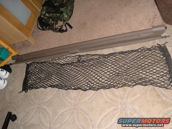 Black cargo net and tan cargo cover on carpeted floor