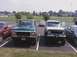 1979 Ford Bronco - Two Ford trucks are parked in a lot, one green and one light blue, with other vehicles in the background.