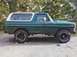 1979 Ford Bronco - A green and white 1979 Ford Bronco is parked outdoors on a gravel surface.