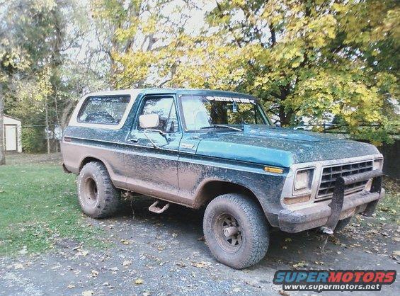 Mud-splattered 1978 Ford Bronco with aftermarket hood scoop and brush guard