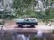 1979 Ford Bronco - 1978 Ford Bronco parked on the edge of a body of water surrounded by trees.