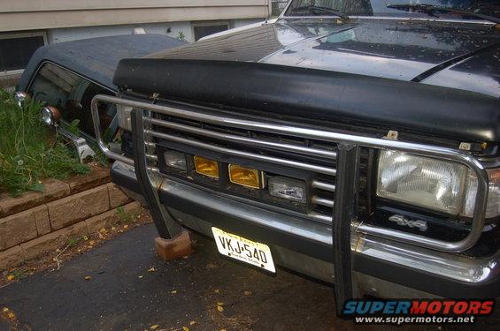 Dark blue Ford Bronco front end with a chrome bull bar and yellow fog lights. License plate VKJ-540 is visible