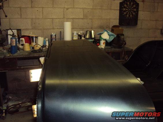 Dark vehicle body in garage, side view